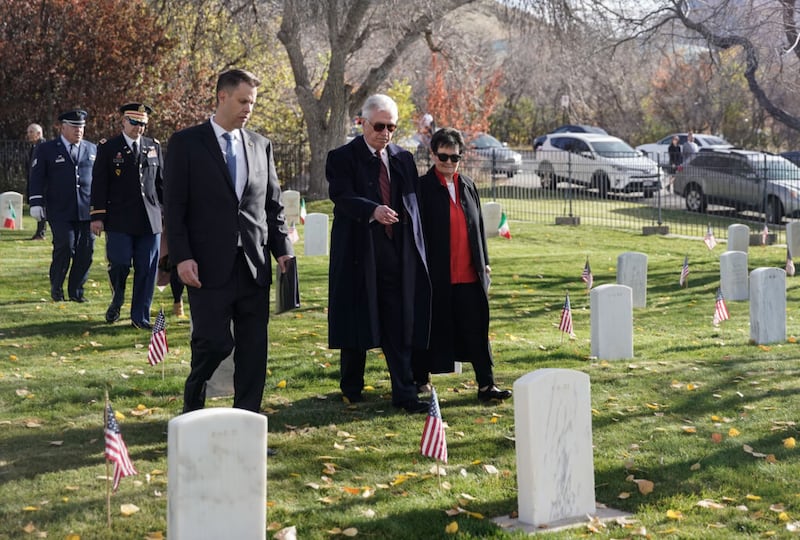 El élder Dieter F.Uchtdorf, en el centro, y su esposa, la hermana Harriet F.Uchtdorf, el cónsul honorario de Alemania James T. Burton, a la izquierda, muestran su respeto mientras participan en el evento Volkstrauertag en el cementerio militar de Fort Douglas el domingo, 14 de noviembre de 2021 en Salt Lake City.