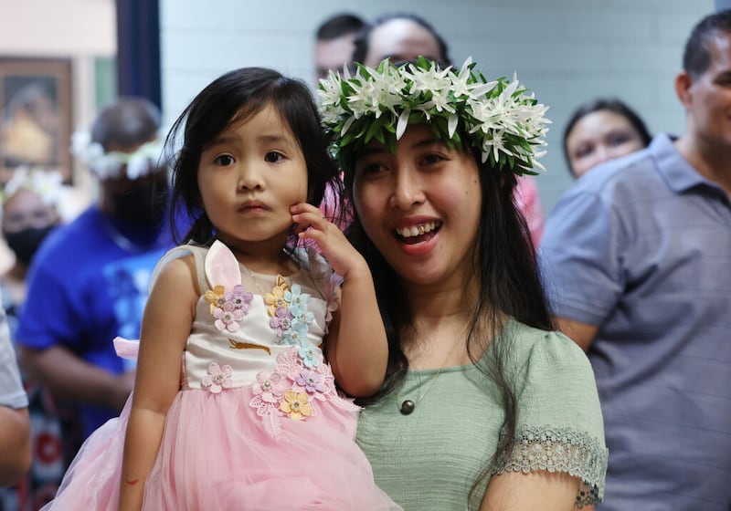 Saera Walter y su sobrina Zebella Cheng observan a los artistas mientras los miembros de la Iglesia celebran la dedicación del Templo de Yigo Guam en el Centro de Estaca Barrigada en Guam el viernes, 20 de mayo de 2022.