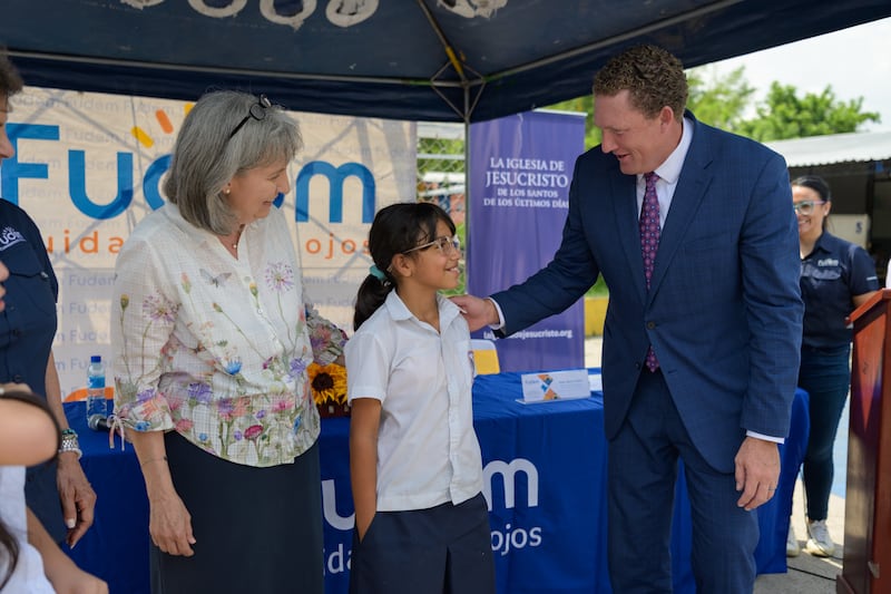 La hermana J. Anette Dennis y el élder Ryan K. Olsen anuncian la donación de anteojos y exámenes de la vista en San Salvador, El Salvador, el viernes 5 de junio.