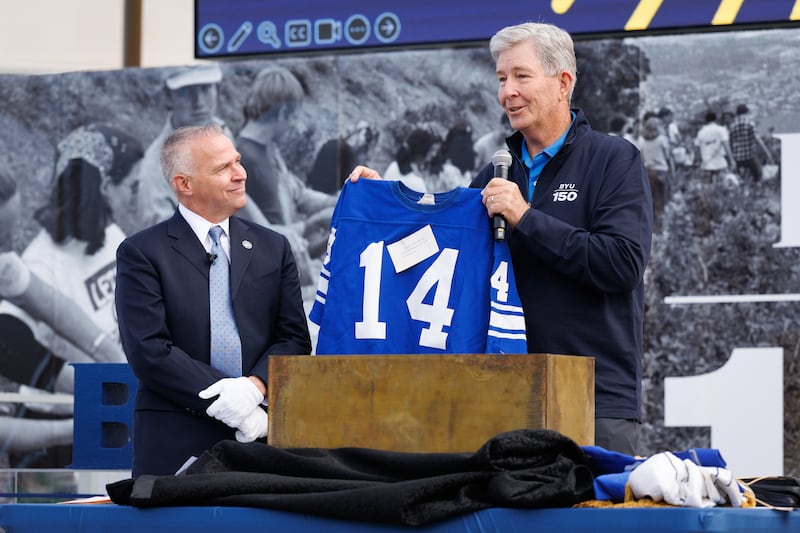 El élder S. Gifford Nielsen, exquarterback de BYU, sostiene su camiseta número 14, que fue incluida en la cápsula del tiempo colocada en la biblioteca en 1976 durante el aniversario del centenario de la Universidad Brigham Young. La cápsula del tiempo fue abierta durante un evento del Día del Fundador en Brigham Square en Provo, Utah, el jueves 16 de octubre de 2025.