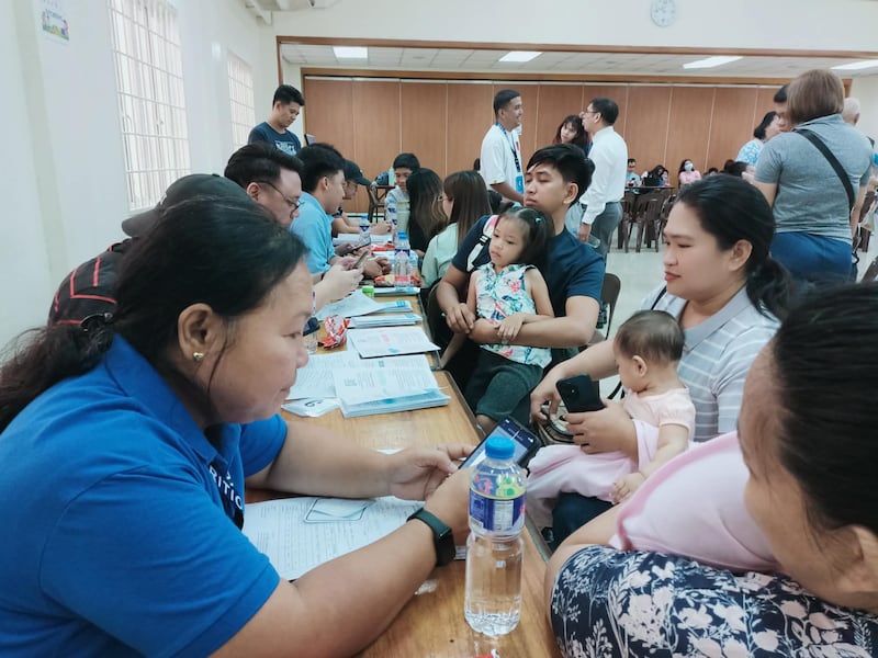 Padres sostienen a sus hijos en el Centro de Estaca de Pasay, Filipinas, durante una evaluación de nutrición infantil el 18 de abril de 2026.